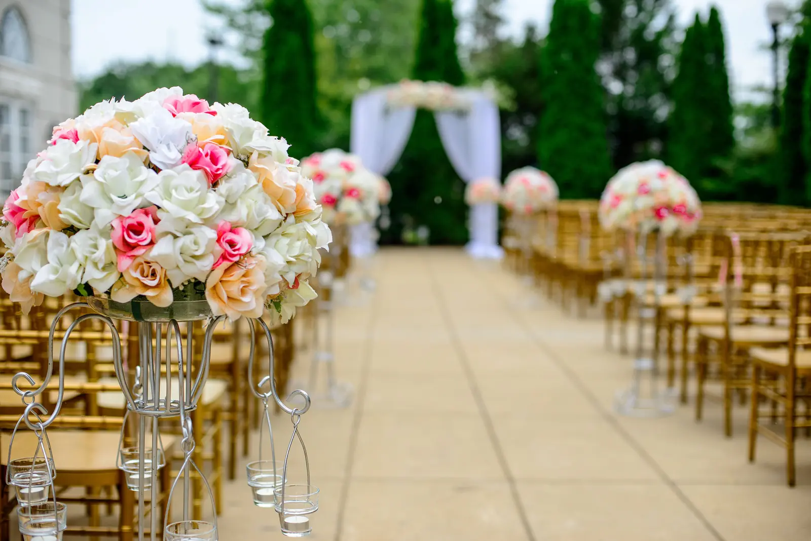 Chairs set out either side of a paved aisle lined with roses